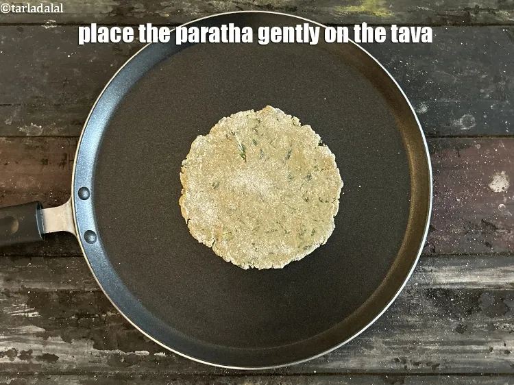 Step 16 – <meta charset="UTF-8" />Place the paratha gently on the tava.&nbsp;&nbsp;&nbsp;<br /> &nbsp;