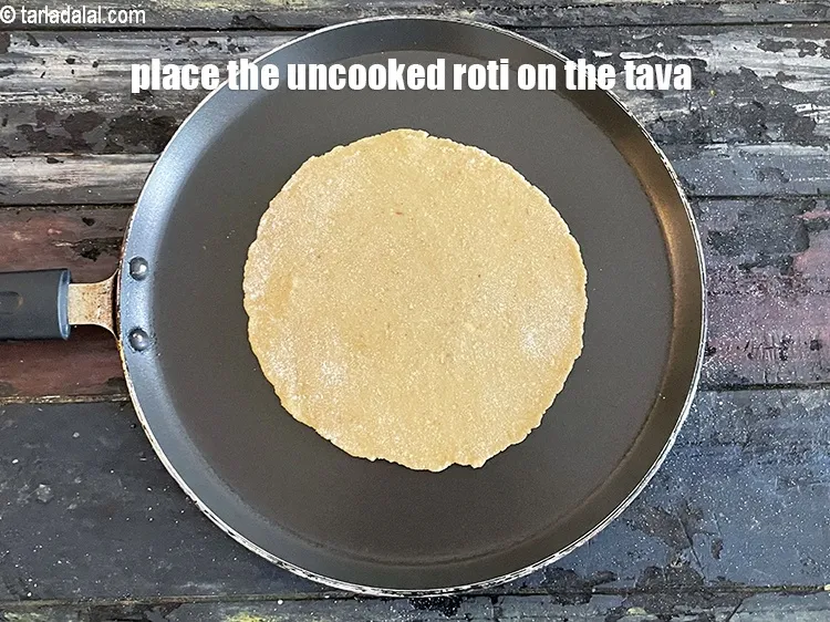 Step 16 – Place the rolled uncooked roti on the tava.&nbsp;