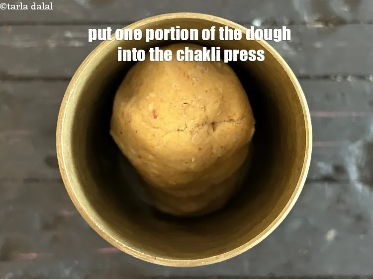 Step 16 – Put one portion of the dough into a chakli press.