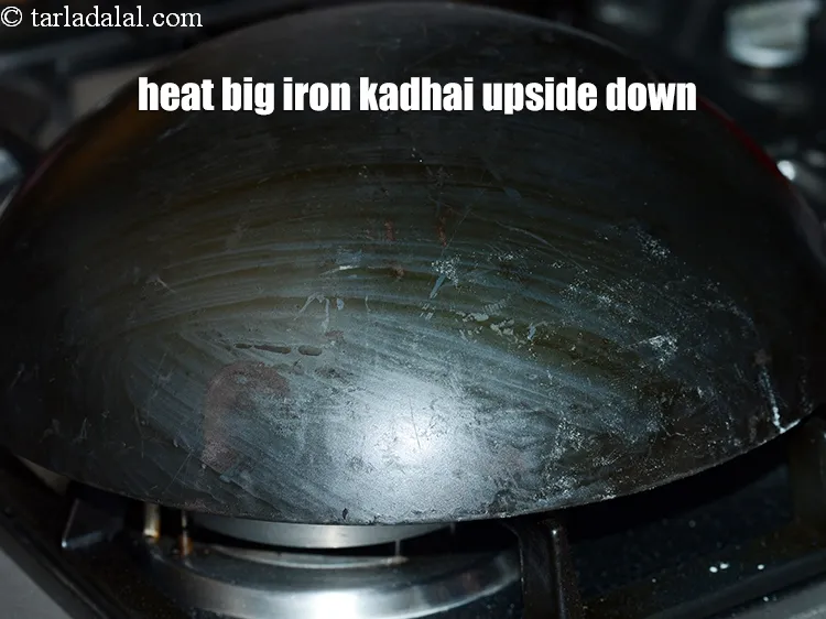 Step 16 – Heat a big iron kadhai upside down. You can also use an&nbsp;aluminium kadhai.