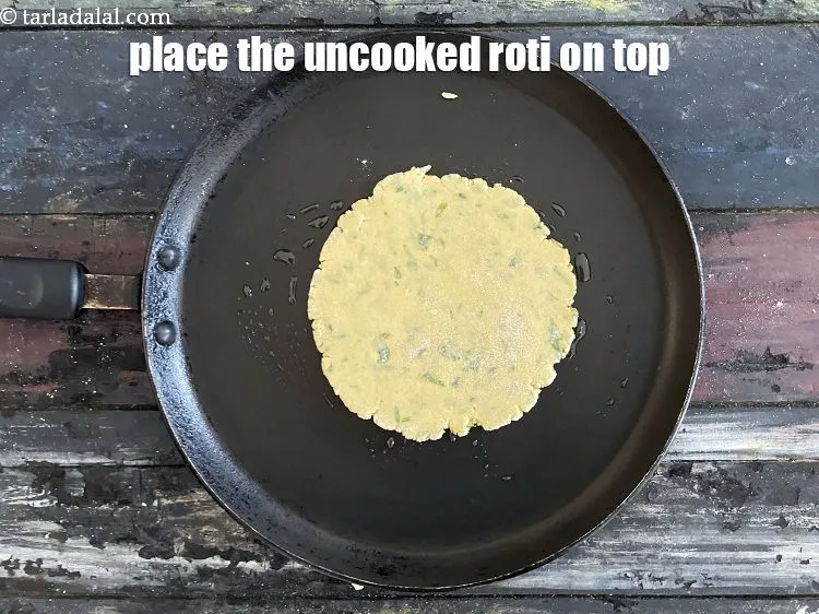 Step 17 – Place the uncooked roti on it.&nbsp;<br /> &nbsp;