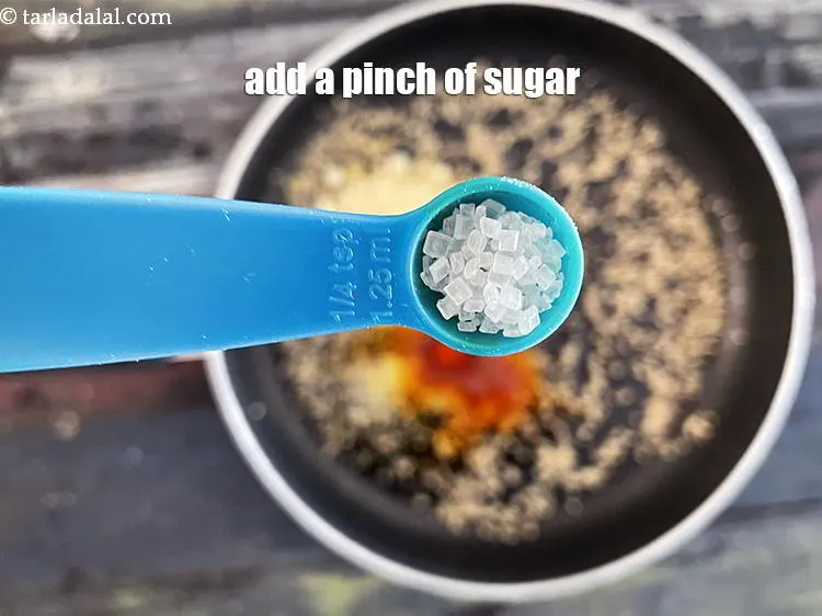 स्टेप 14 – एक चुटकी&nbsp;<a href=""https://www.tarladalal.com/glossary-sugar-chini-shakkar-hindi-278i"">शक्कर</a>&nbsp;डालें।