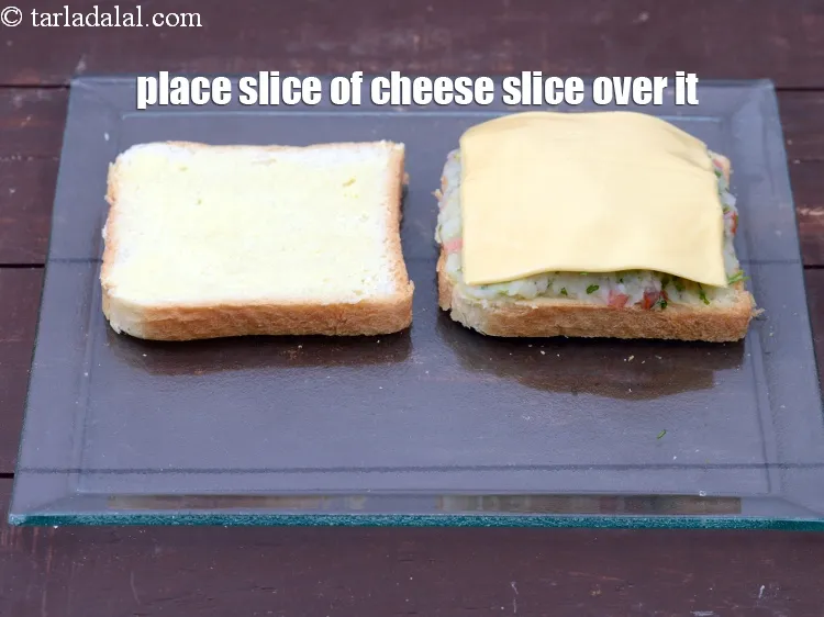 Step 15 – Place a slice of <a href="https://tarladalal.com/glossary-cheese-slices-765i">cheese slice</a>&nbsp;over the potato stuffing.