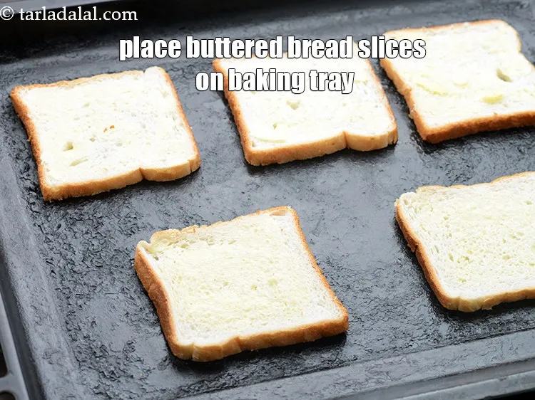 Step 15 – Place 5&nbsp;<a href="https://www.tarladalal.com/glossary-bread-219i">bread slices</a>&nbsp;on a baking tray with the buttered side facing upwards.