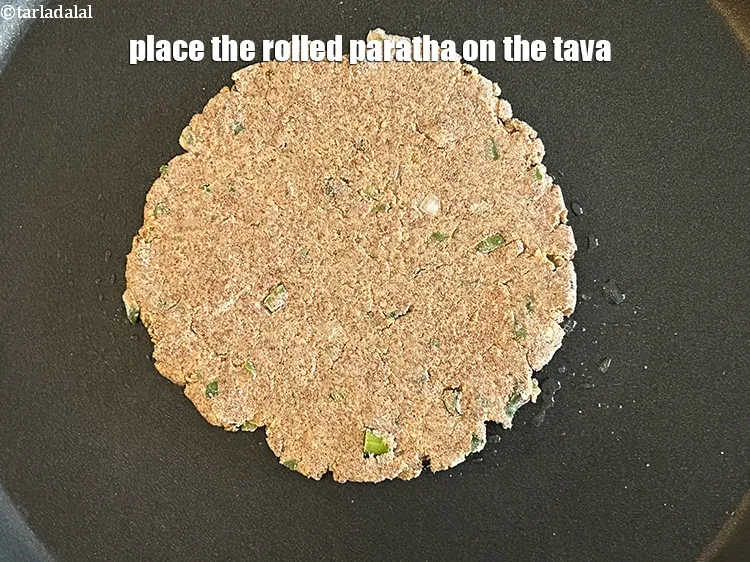 Step 15 – Place the rolled paratha on the tava.