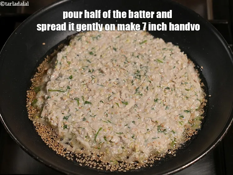 Step 16 – Pour half of the batter and spread it gently on make 7 inch handvo.