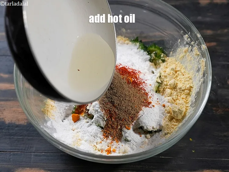 Step 16 – Add 1 tsp&nbsp;hot&nbsp;<a href="https://www.tarladalal.com/glossary-oil-671i">oil</a>.