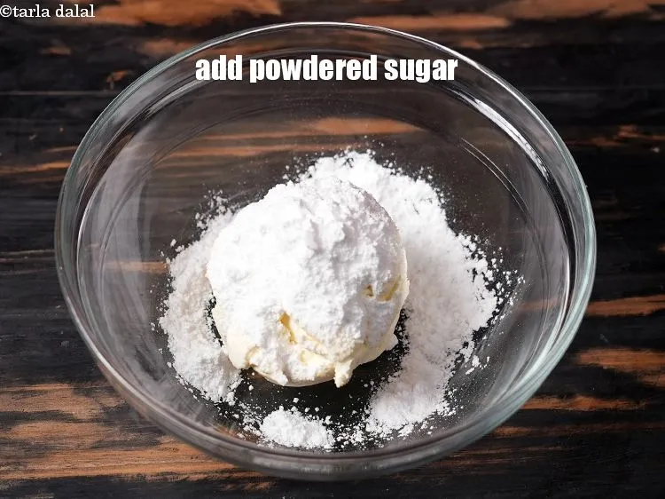 Step 17 – Add &frac14; cup <a href="https://www.tarladalal.com/glossary-powdered-sugar-280i">powdered sugar</a>.