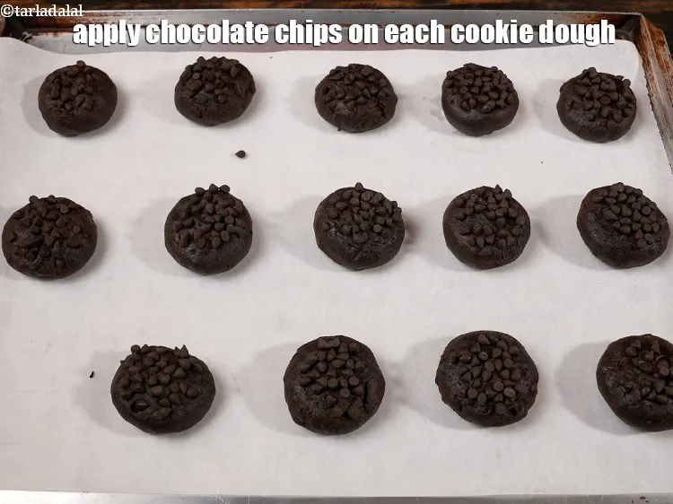 स्टेप 16 – प्रत्येक कुकी आटे पर चॉकलेट चिप्स लगाएं।