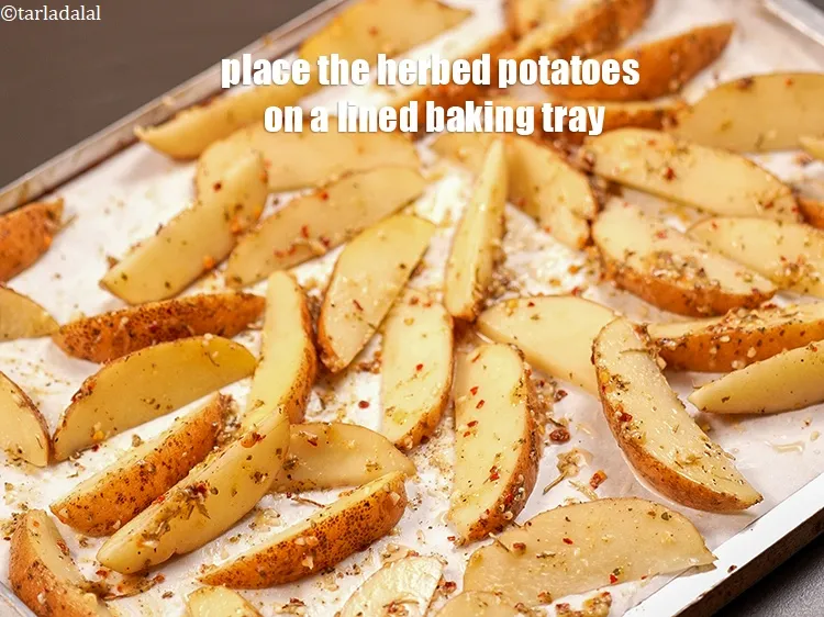 स्टेप 16 – जड़ी-बूटी वाले आलू को एक पंक्तिबद्ध बेकिंग ट्रे पर रखें।