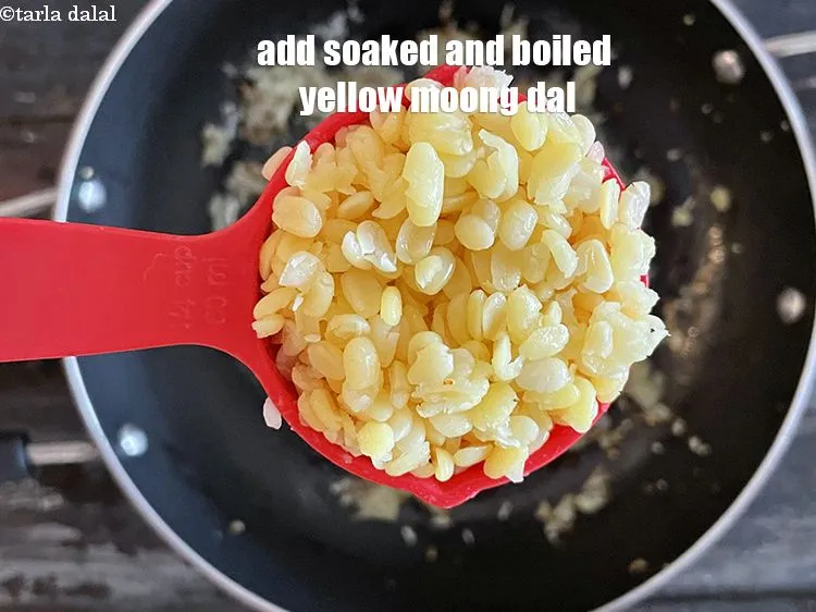 Step 32 – Add&nbsp;<meta charset="UTF-8" />1/4 cup&nbsp;soaked and&nbsp;<a href="glossary-boiled-yellow-moong-dal-1443i">boiled yellow moong dal (split yellow gram)</a>.