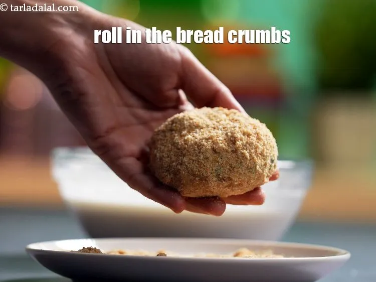 Step 21 – Roll in the&nbsp;<a href="https://www.tarladalal.com/glossary-bread-crumbs-breadcrumbs-222i">bread crumbs</a>&nbsp;till they are evenly coated from all the sides.