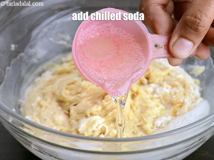Step 18 – Add &frac14; cup chilled&nbsp;<a href="https://www.tarladalal.com/glossary-soda-club-water-614i">soda</a>.