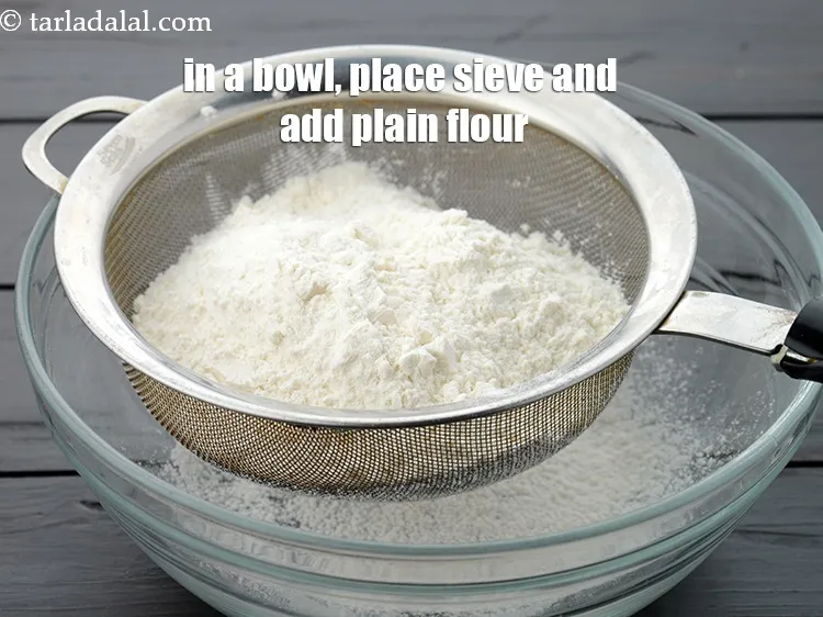 Step 16 – In a deep bowl, place a sieve and add 1 1/4 cups &nbsp;<a href="https://www.tarladalal.com/glossary-plain-flour-maida-188i">plain flour …