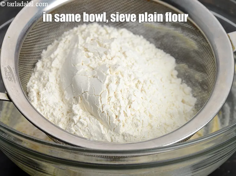 Step 16 – In the same bowl, sieve 1 cup&nbsp;<a href="https://www.tarladalal.com/glossary-plain-flour-maida-188i">plain flour (maida)</a>
