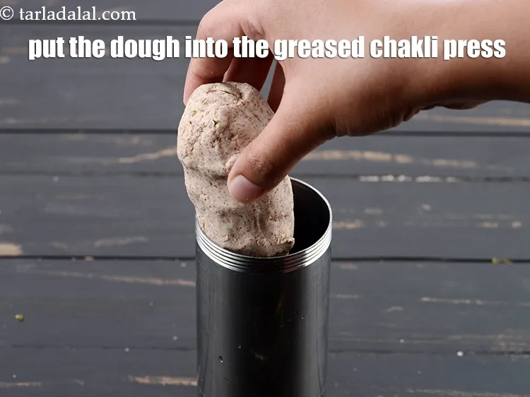 Step 16 – Put the dough into the greased 'chakli press'.
