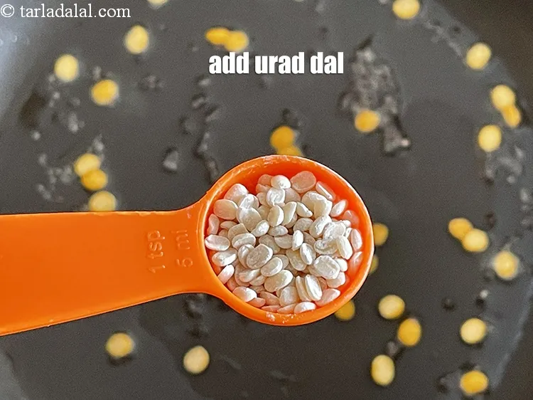 Step 16 – Add 2&nbsp;tsp&nbsp;<a href="glossary-urad-dal-split-black-lentil-941i">urad dal (split black lentils)</a>.