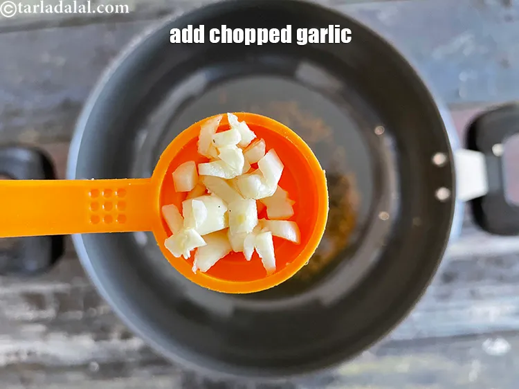 Step 28 – Add&nbsp;<meta charset="UTF-8" />1/2 tsp&nbsp;finely&nbsp;<a href="glossary-chopped-garlic-790i">chopped garlic (lehsun)</a>.