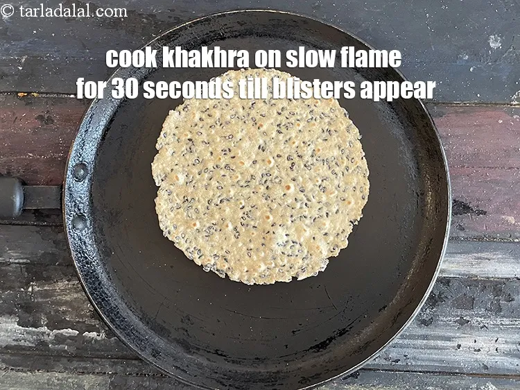 Step 15 – Cook khakhra on a slow flame&nbsp;for 30 to 45 seconds till blisters (bubbles ) appear.&nbsp;