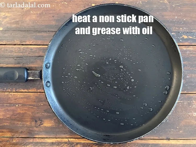 Step 16 – <meta charset="UTF-8" /> Heat a non-stick tava (griddle) and grease it with oil. &nbsp; &nbsp;