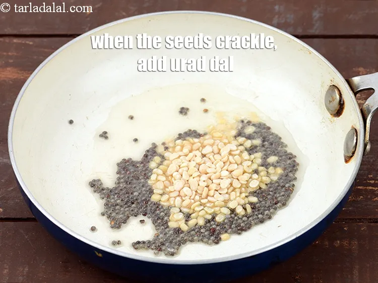 स्टेप 16 – जब बीज चटकने लगे तो&nbsp;१ टी-स्पून&nbsp;<a href=""https://www.tarladalal.com/glossary-urad-dal-split-black-lentil-hindi-941i"">उड़द की दाल</a>&nbsp;डालें।