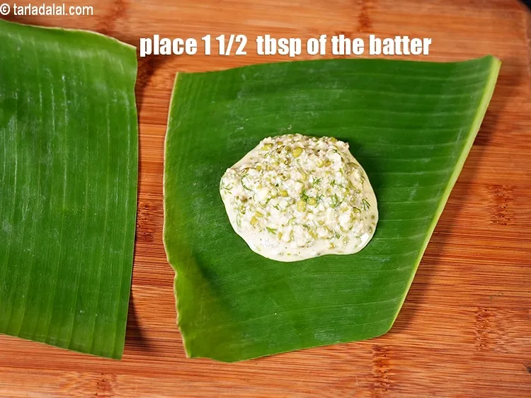 Step 19 – Place 1 1/2&nbsp;&nbsp;tbsp of the batter on one half of the banana leaf and spread …
