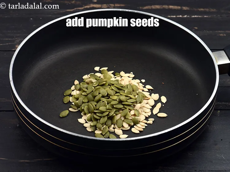 स्टेप 16 – 2 टेबल्स्पून कच्चे&nbsp;&nbsp;<a href=""https://www.tarladalal.com/glossary-pumpkin-seeds-pepitas-kaddu-ke-beej-hindi-857i"" target=""_blank"">कद्दू के बीज</a>&nbsp;डालें ।