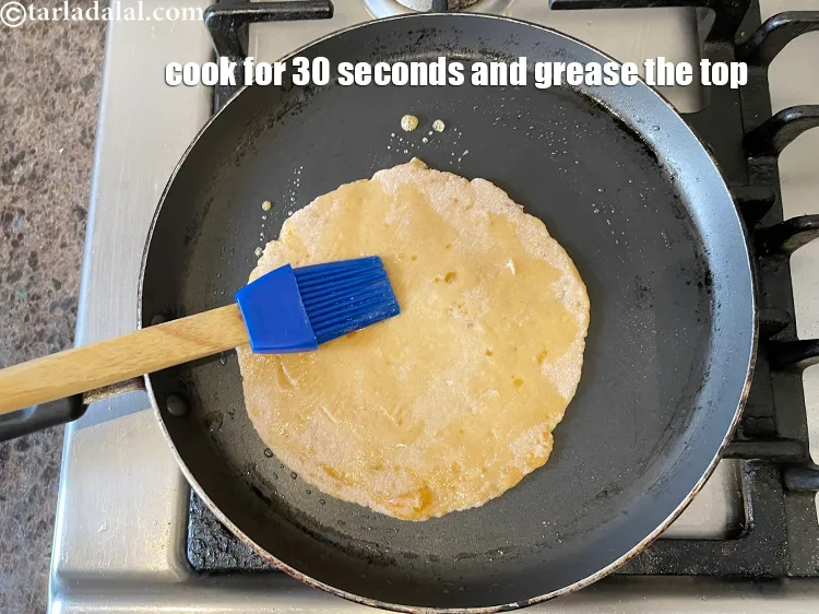 Step 17 – Cook for 30 seconds while greasing the paratha on top.