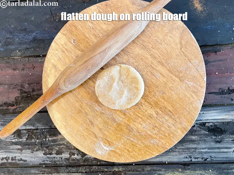 स्टेप 17 – आटे को चकले पर चपटा कर लें।