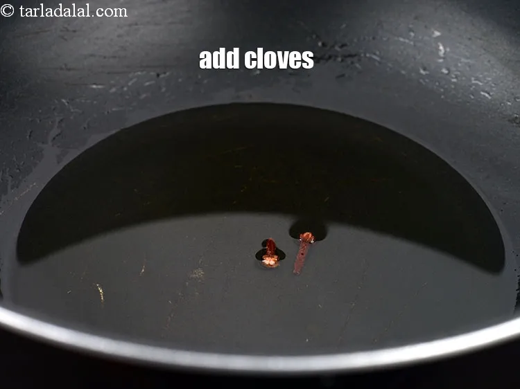 Step 16 – Add 2 <a href="https://www.tarladalal.com/glossary-cloves-laung-lavang-322i">cloves (laung / lavang)</a>.