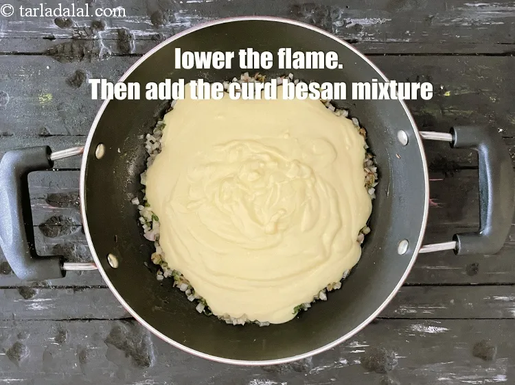 Step 16 – Lower the flame and add the curds-besan mixture.