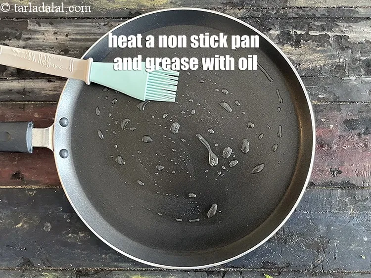 Step 18 – <meta charset="UTF-8" />Heat a non-stick tava (griddle) and grease it with oil.&nbsp;&nbsp;<br /> &nbsp;