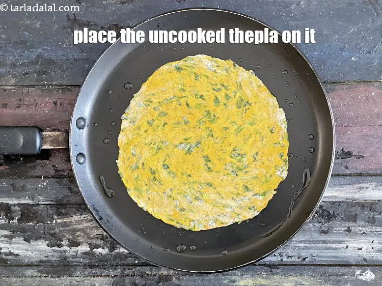 Step 16 – Place the rolled thepla on it.