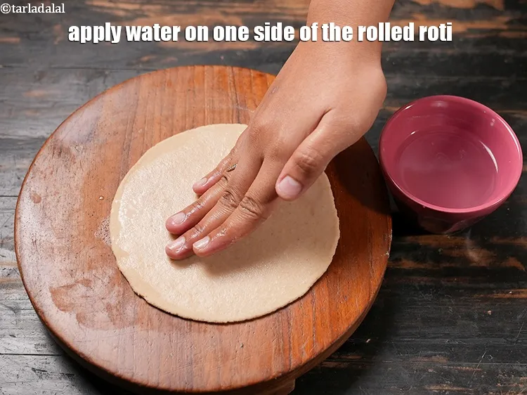 स्टेप 17 – बेली हुई रोटी के एक तरफ पानी लगायें।