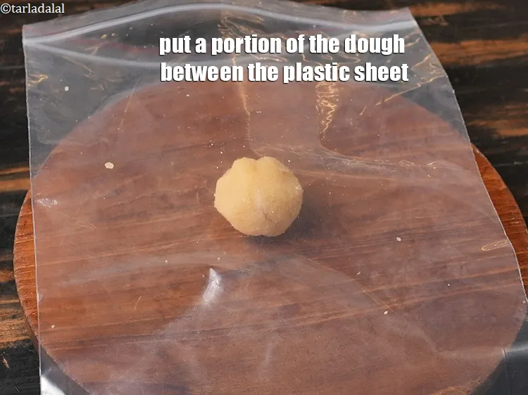 Step 25 – <meta charset="UTF-8" /> Put a portion of the dough between the plastic&nbsp;sheet. &nbsp;