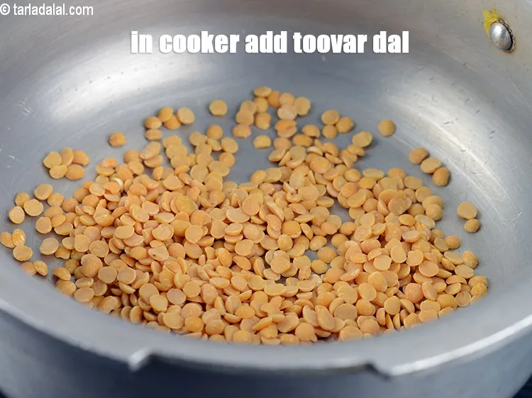 Step 18 – In a pressure cooker add &frac14; cup <a href="https://www.tarladalal.com/glossary-toovar-dal-arhar-dal-toor-dal-split-pigeon-peas-tur-dal-955i">toovar (arhar) dal</a>.