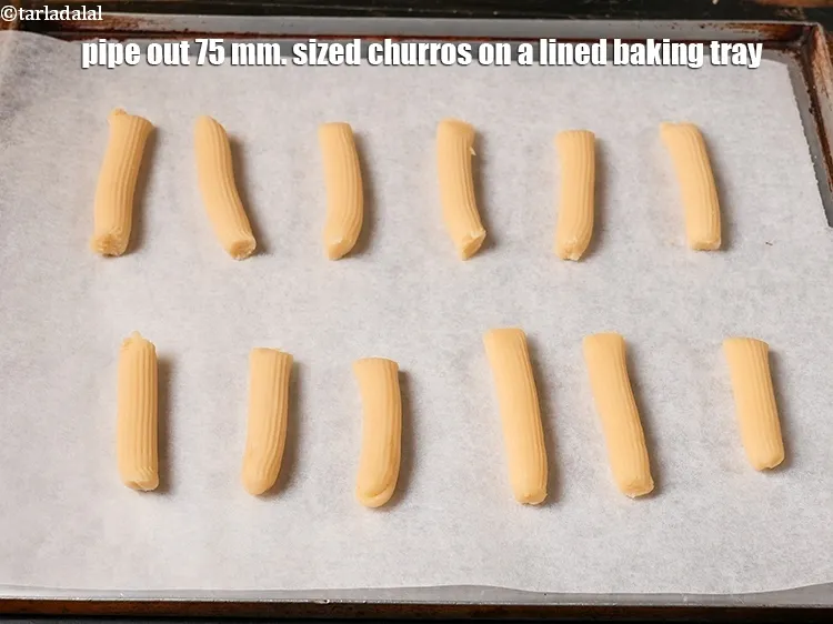 Step 18 – Pipe out 75 mm. (3 inch) sized churros on a lined baking tray.