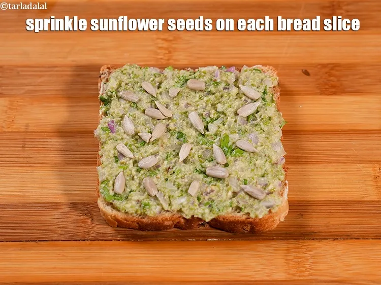 Step 17 – Sprinkle &frac12; tsp <a href="https://www.tarladalal.com/glossary-sunflower-seeds-surajmukhi-ke-beej-611i">sunflower seeds (surajmukhi ke beej)</a>&nbsp; on each bread slice.&nbsp;