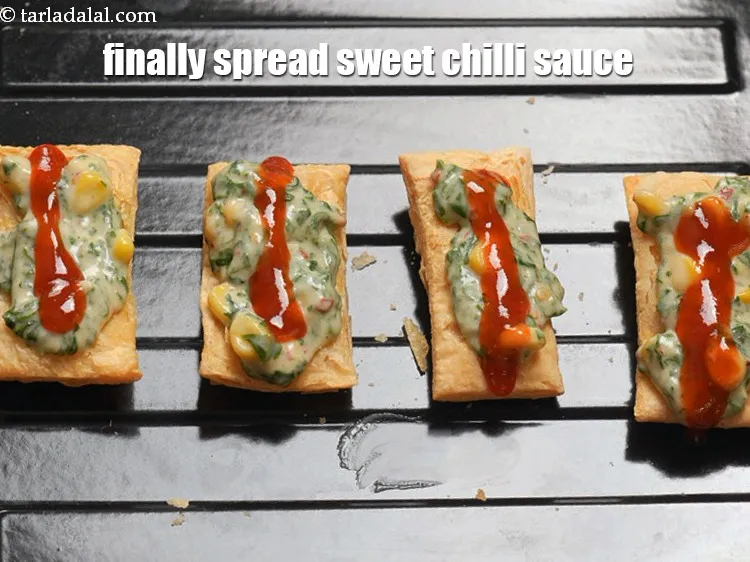 Step 17 – Finally spread &frac12; tsp&nbsp;<a href="https://www.tarladalal.com/glossary-hot-and-sweet-chilli-sauce-1600i">hot and sweet chilli sauce</a>.