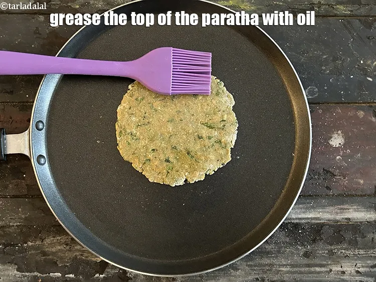 Step 18 – <meta charset="UTF-8" />Grease the top of the paratha with oil using a brush.
