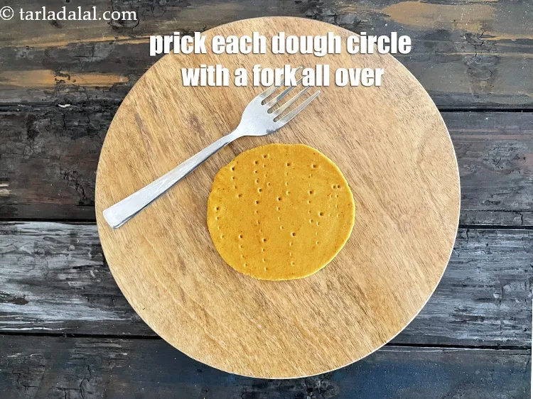 Step 17 – Prick them using a fork&nbsp;at regular intervals. <strong>We are pricking them so the puris don't …