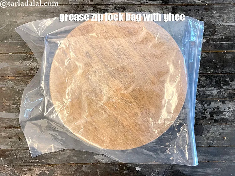 Step 57 – On a rolling board place a zip lock bag and grease it with ghee.