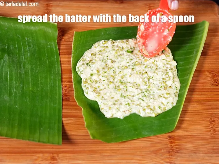 Step 20 – <meta charset="UTF-8" />Spread the batter with the back of a spoon on the banana leaf.&nbsp;&nbsp;&nbsp;
