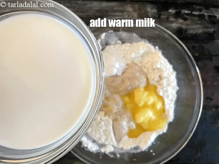 Step 21 – Add 1 1/4 th&nbsp;cup&nbsp;warm&nbsp;<a href="glossary-milk-doodh-full-cream-milk-514i">milk</a>.