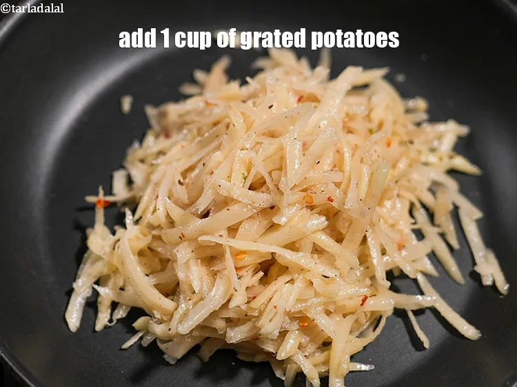 Step 18 – Add 1 cup of <a href="https://www.tarladalal.com/glossary-grated-potatoes-867i">grated potatoes</a>.