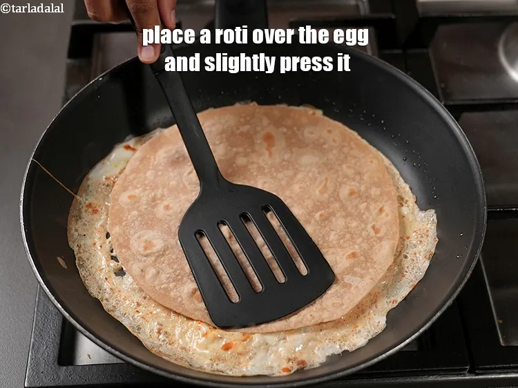 Step 18 – Place a roti over the egg and slightly press it.