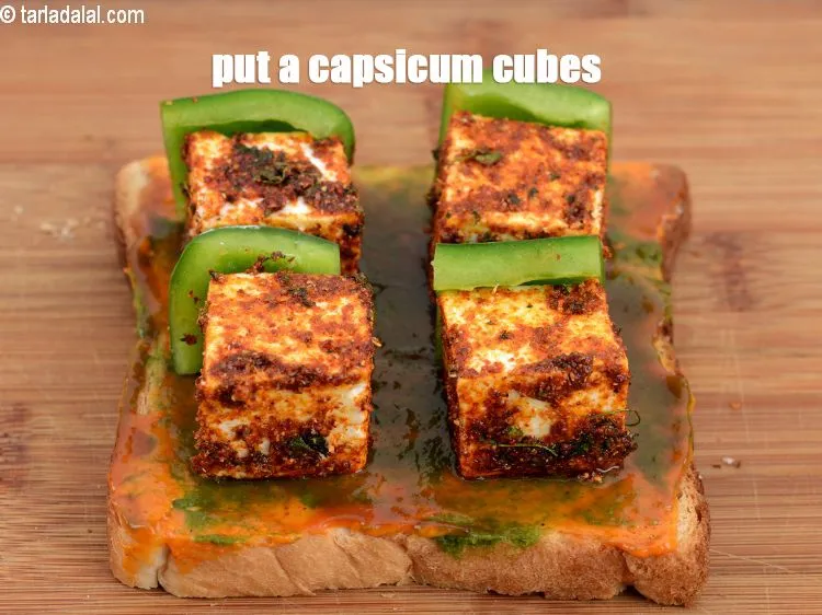 Step 18 – Put a <a href="https://www.tarladalal.com/glossary-capsicum-cubes-170i">capsicum cubes</a> piece near each paneer piece on one side.