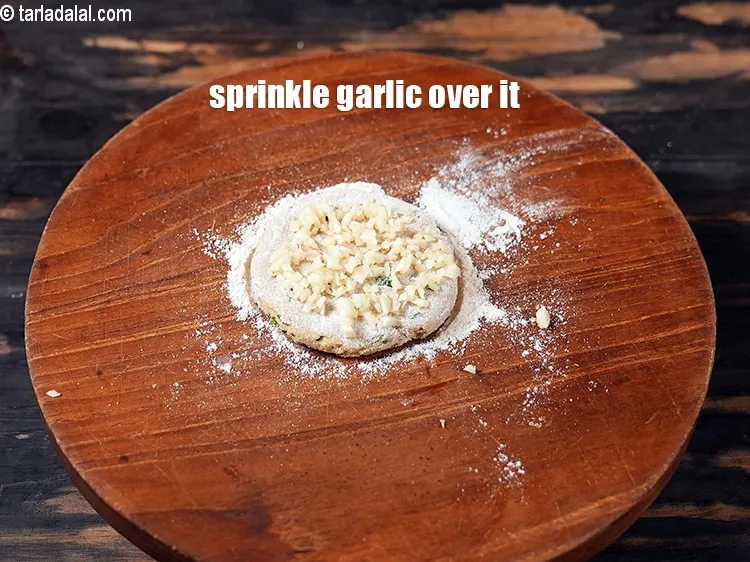 स्टेप 18 – इसके ऊपर 1 टी-स्पून&nbsp;<a href=""https://www.tarladalal.com/glossary-chopped-garlic-hindi-790i"">बारीक कटा हुआ लहसुन</a> छिड़कें।