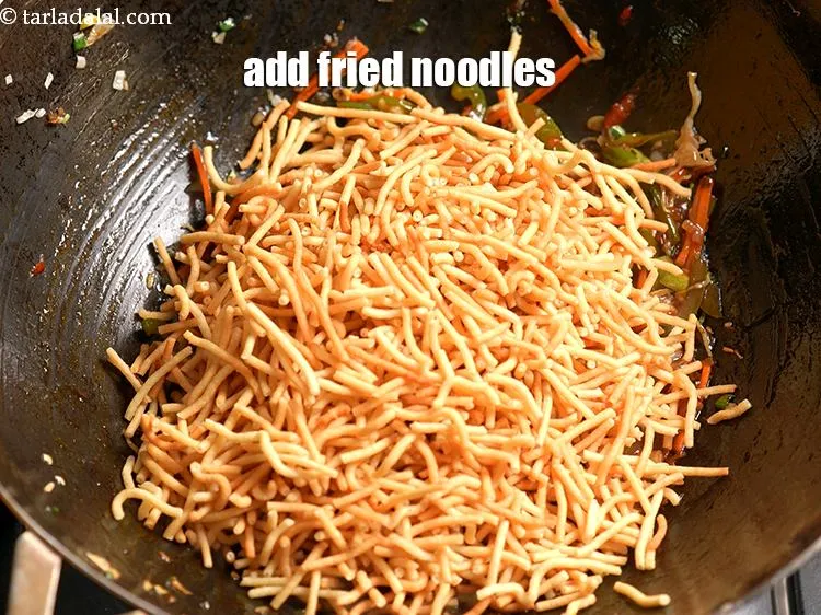 Step 18 – Add 3 cups of <a href="https://www.tarladalal.com/glossary-fried-noodles-1101i">fried noodles</a>.