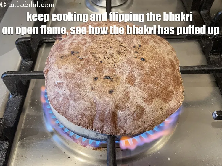 Step 20 – Keep cooking and flipping the bhakri on open flame. See how the bhakri has puffed …